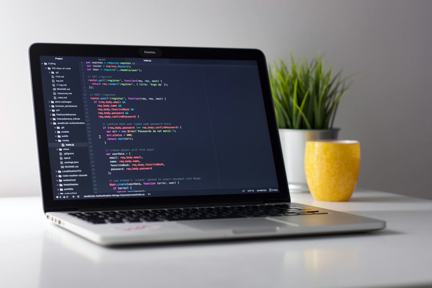 Laptop on a bright desk showing application code