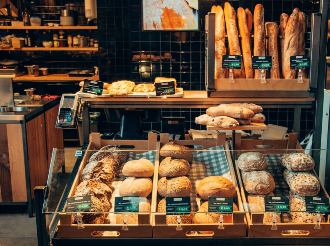 Bakery counter with baguettes and pastries in wooden crates