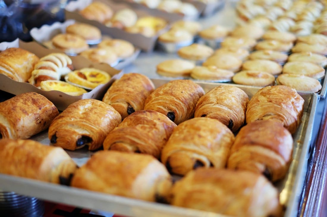 A tray of freshly baked pain au chocolat and custard pastries