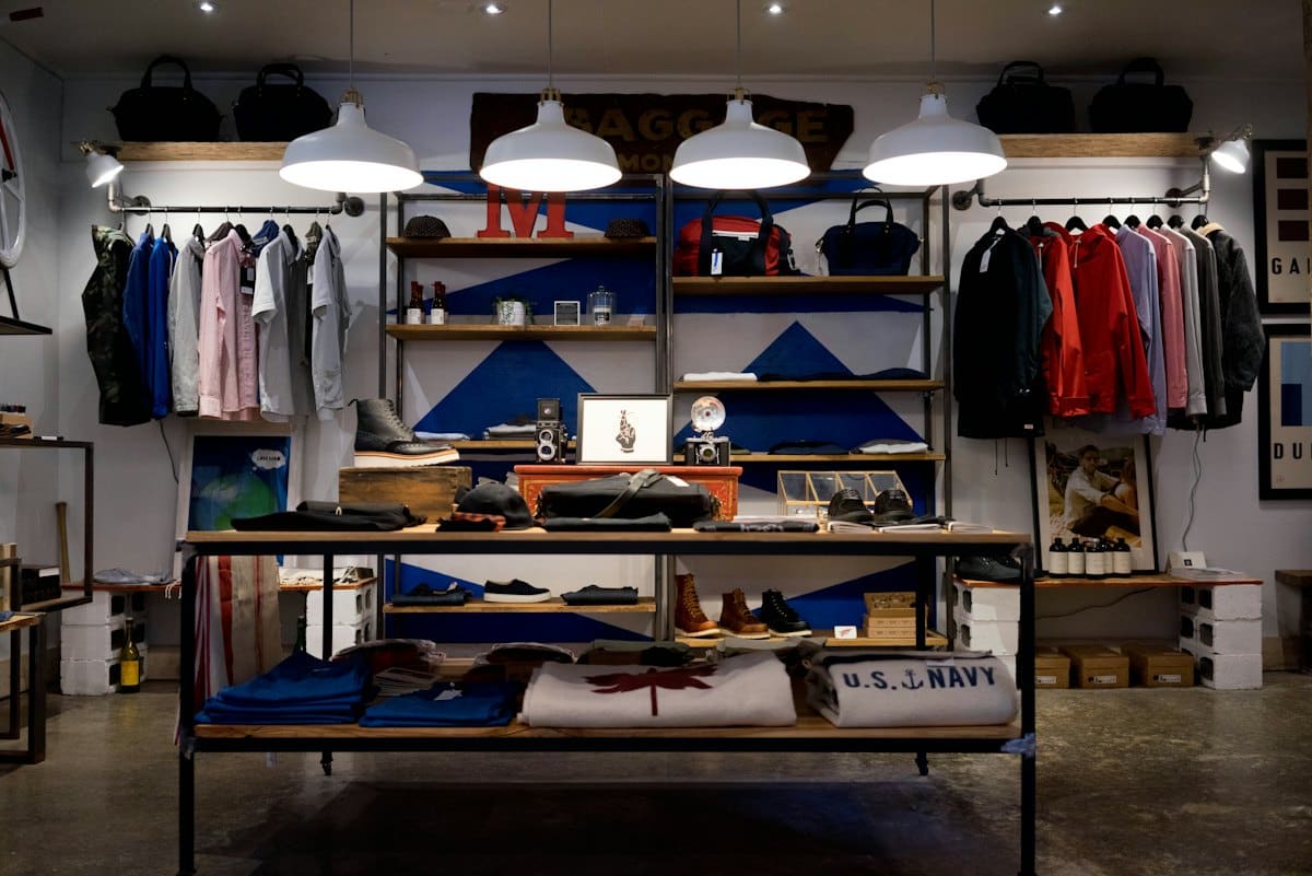 Inside the boutique: warm-lit shelves and rails of folded clothing