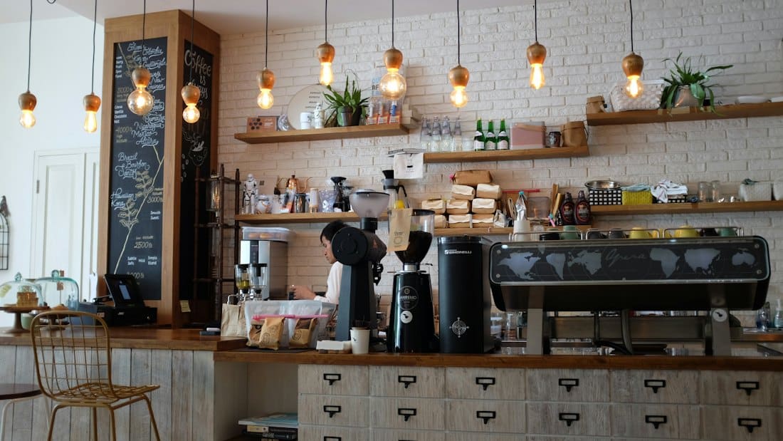 Café counter with espresso machine, chalkboard menu and pendant lights