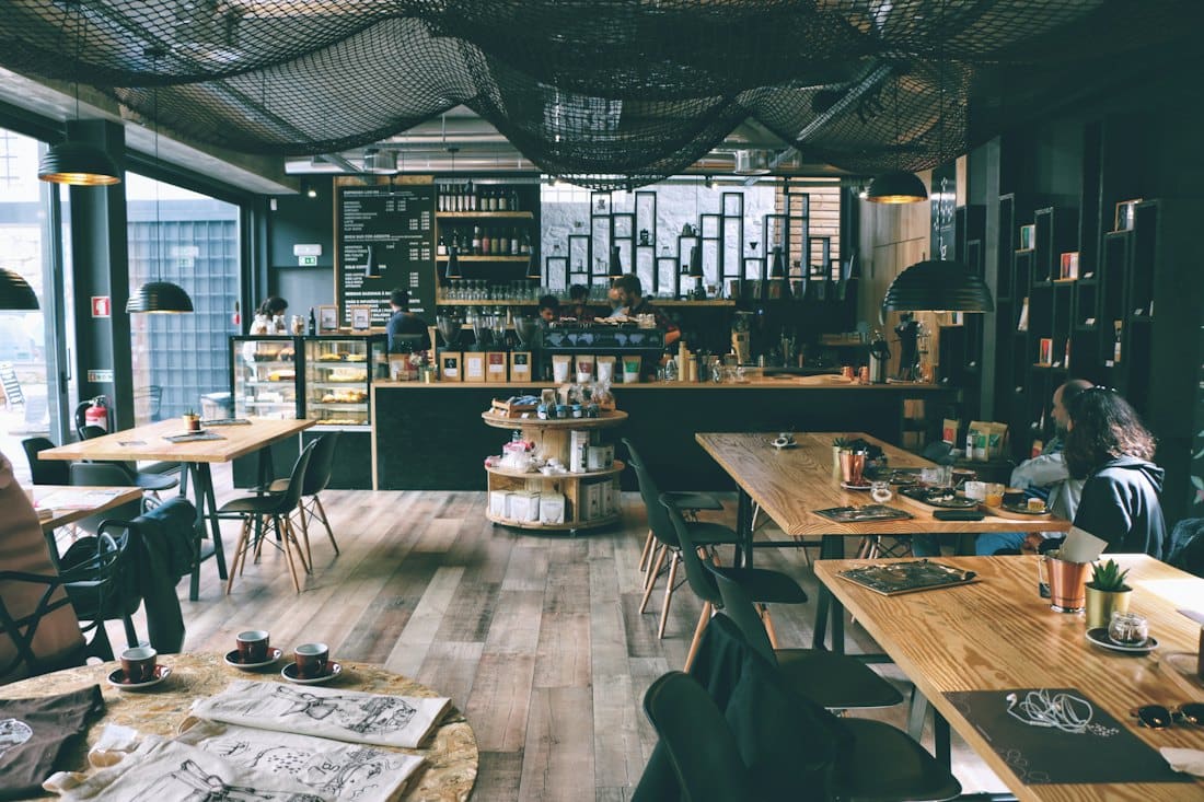 Long communal tables inside a bright industrial-style café