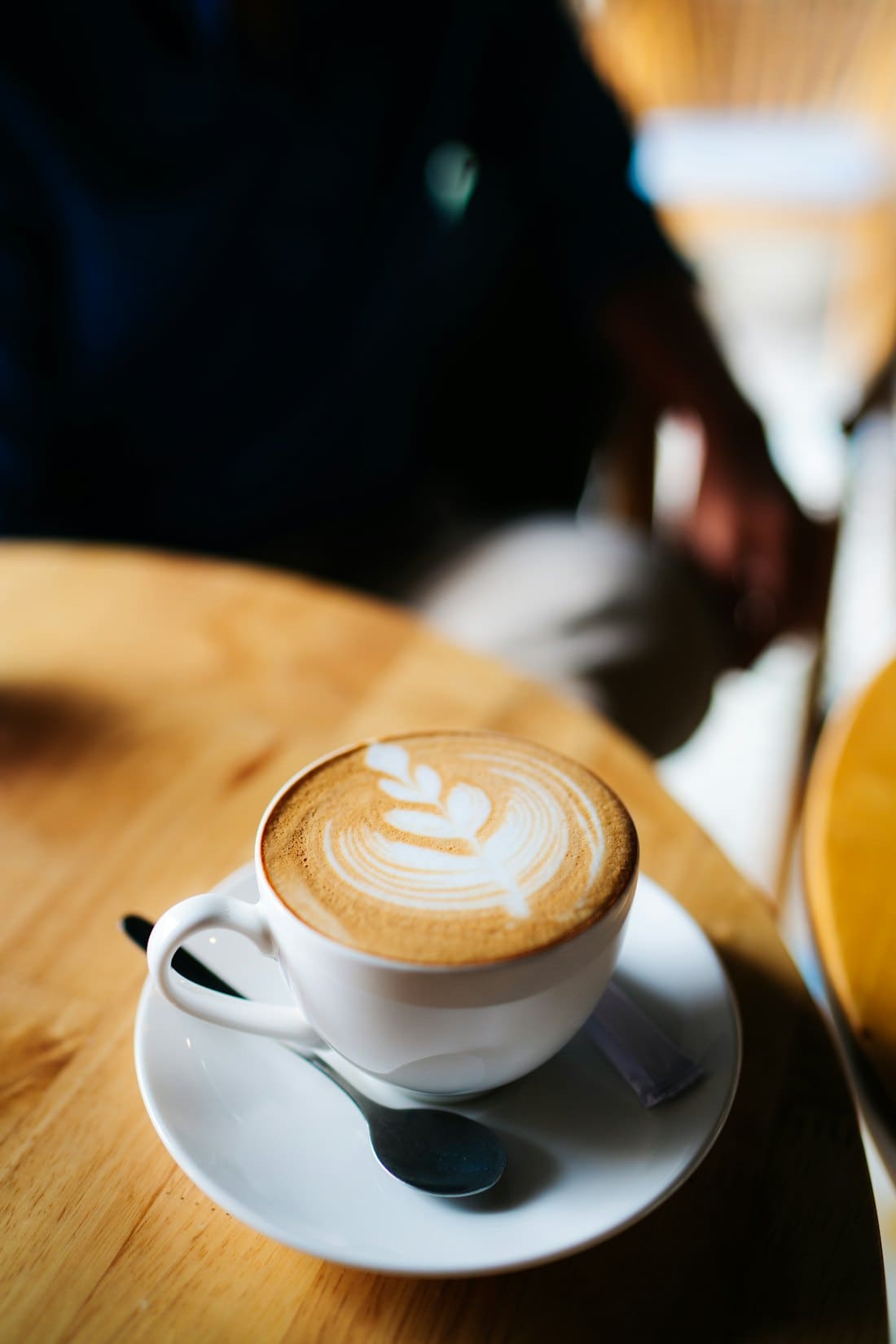 Latte with heart latte art on a saucer by the window