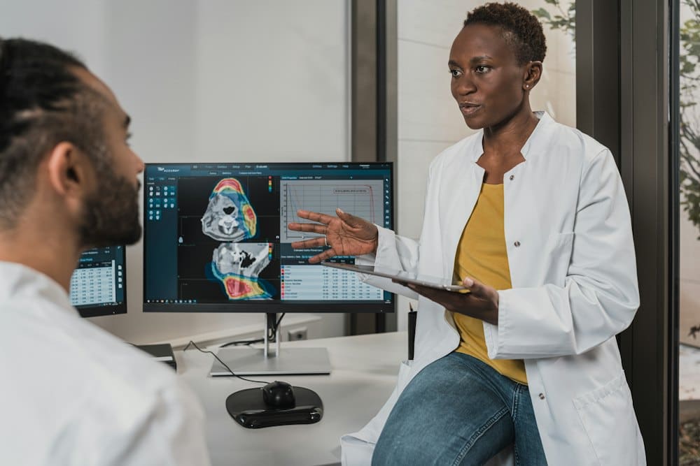 Two clinicians reviewing a scan together on a monitor