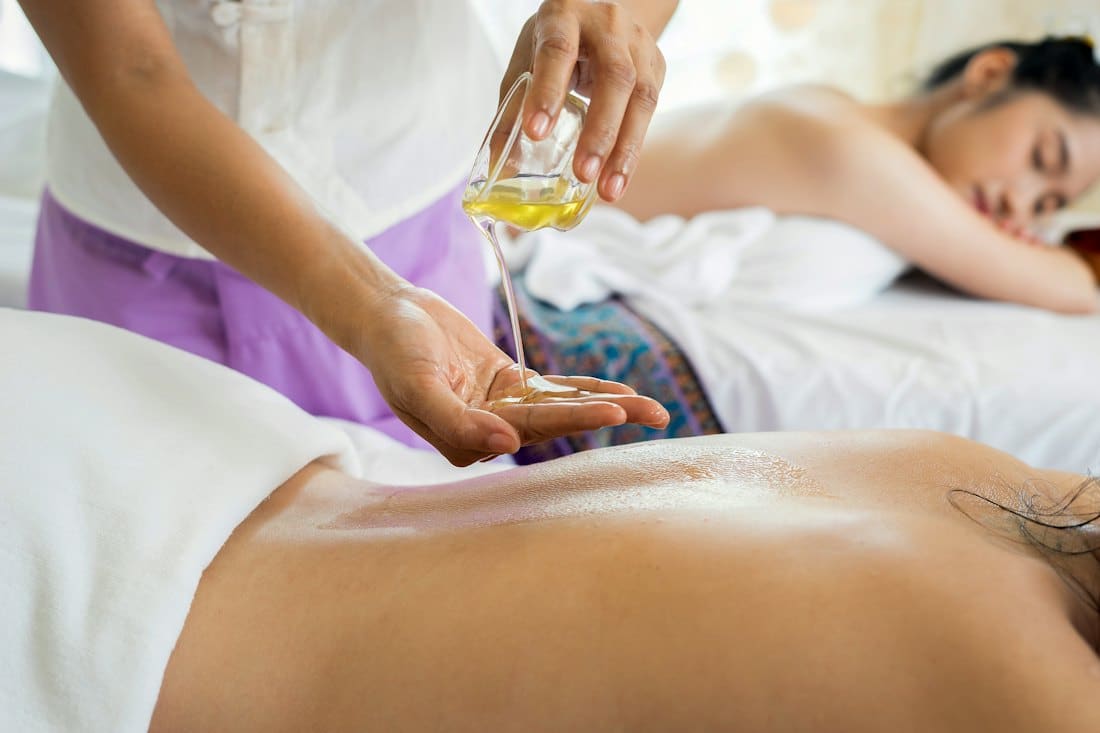 Therapist pouring warm oil during a spa massage