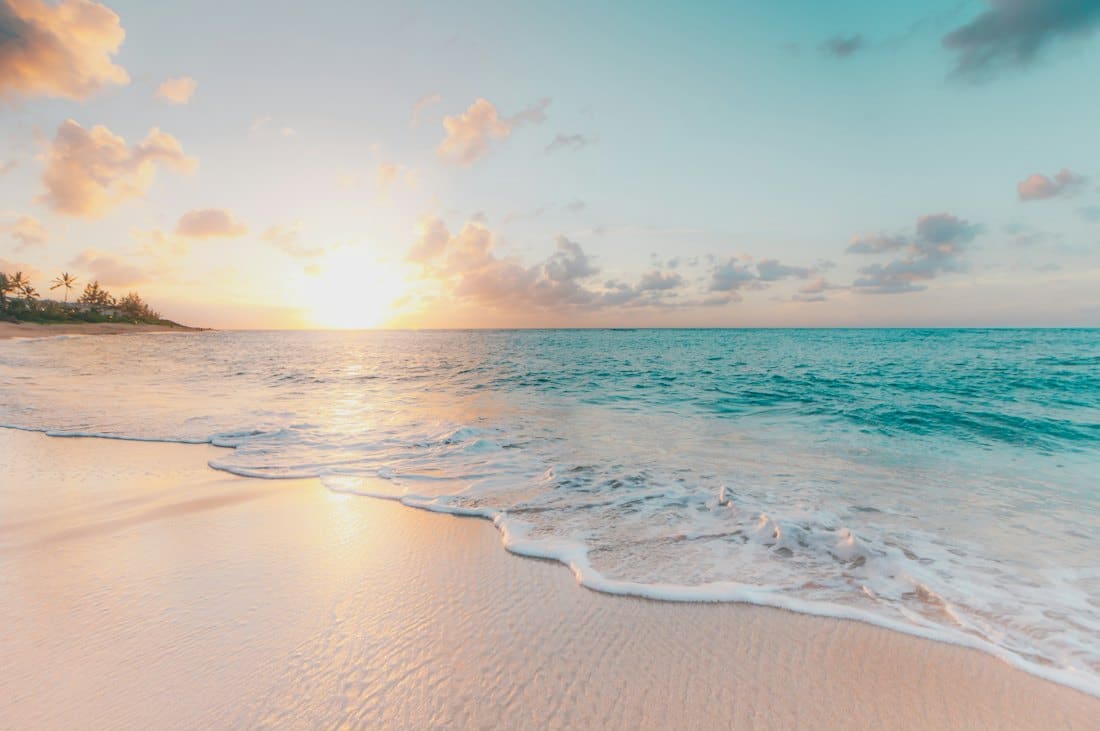 Gentle waves rolling onto a beach at sunrise