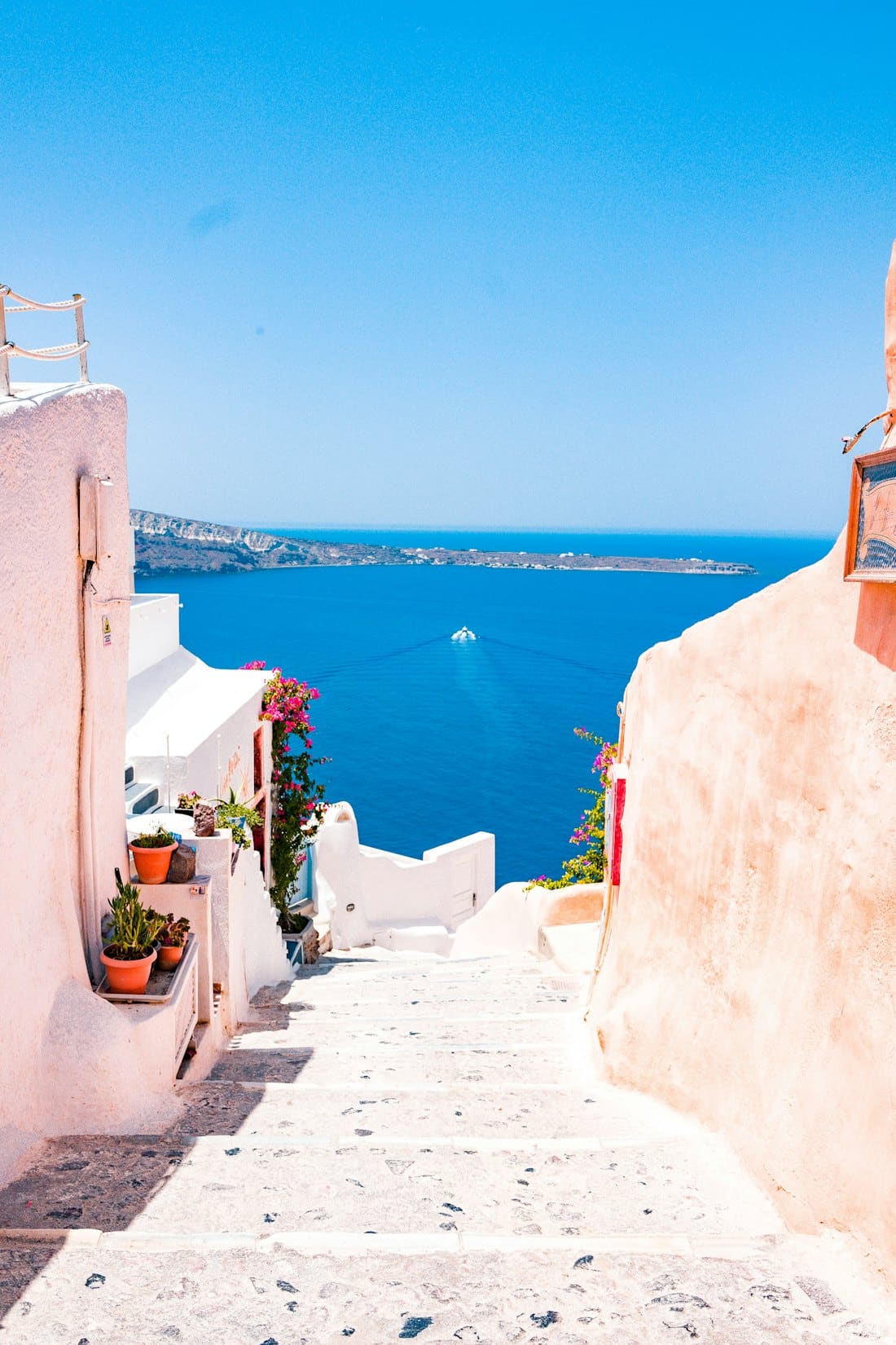 Whitewashed staircase leading down to a deep blue sea